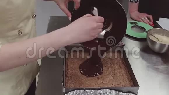 糕点厨师把融化的巧克力倒在烤盘里视频的预览图