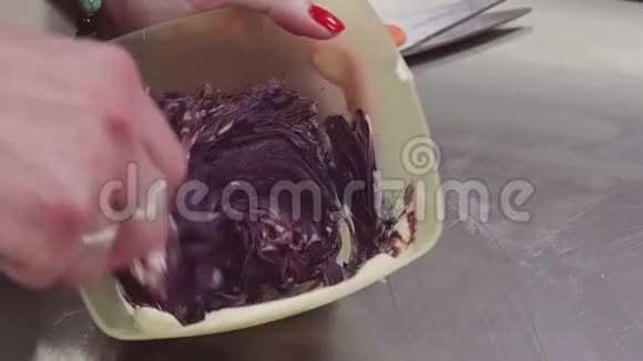 女性手在方碗中混合五颜六色的紫色奶油冻视频的预览图