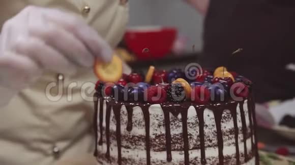 女性糖果师用水果和浆果装饰海绵蛋糕视频的预览图