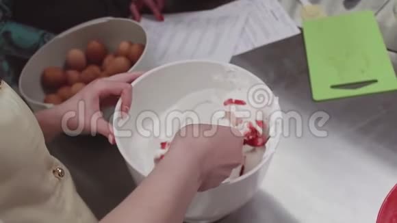 女性糖果师将切好的草莓和鲜奶油混合在厨房视频的预览图