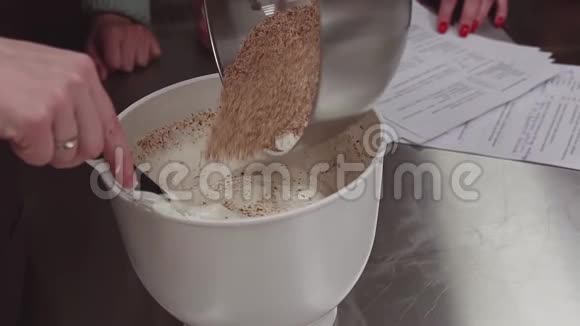 女人糕点师把面包屑和鲜奶油混在一起视频的预览图