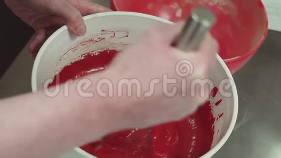 女性糕点师用手搅拌红色面团视频的预览图