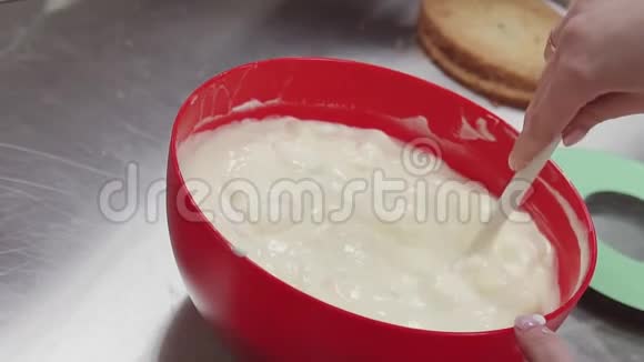 女性手在厨房的搅拌碗中搅动白色的水乳酪视频的预览图
