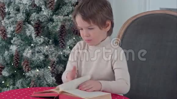 严肃的小男孩在圣诞前夜探索一本书视频的预览图