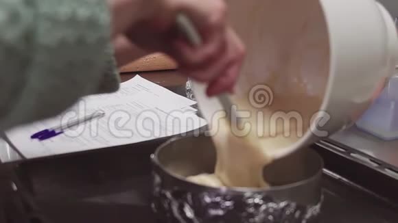 女人的手在厨房里把蛋奶奶洒到烤盘里视频的预览图