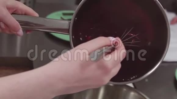 糕点厨师用搅拌器将红色浆果炖成金属锅视频的预览图
