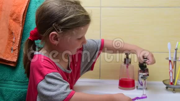 甜甜的小女孩在浴室里刷牙学前观念童年观念可爱的女孩穿着睡衣视频的预览图