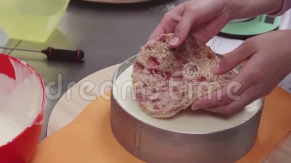 女性糖果手在奶油上以烘焙的形式放小蛋糕视频的预览图
