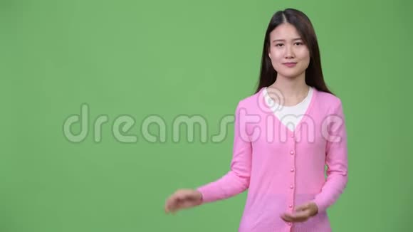 年轻漂亮的亚洲女人展示了一些东西视频的预览图