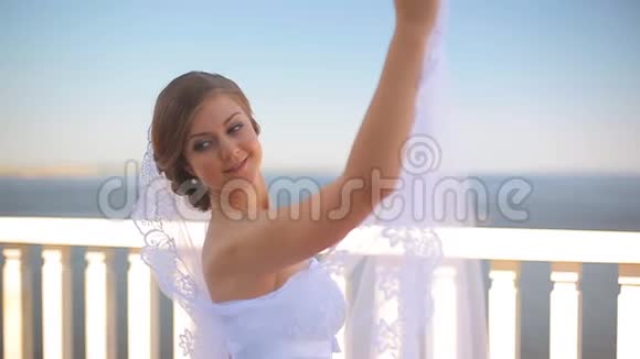 新娘在美丽的阳台上跳婚纱舞俯瞰大海视频的预览图