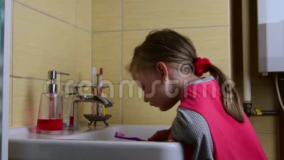 甜甜的小女孩在浴室里刷牙学前观念童年观念可爱的女孩穿着睡衣视频的预览图