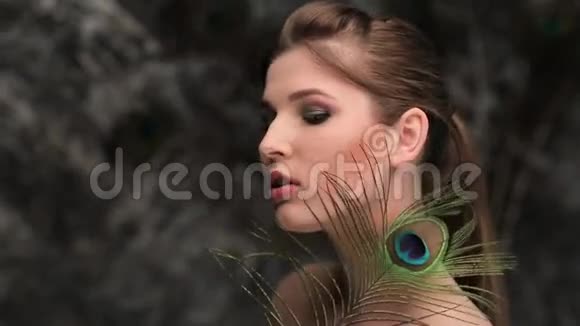 镜头前带着孔雀羽毛调情的女人视频的预览图