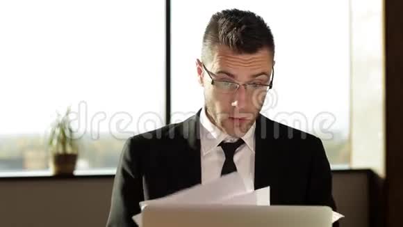 商人在办公室里坐在办公桌前扔文件视频的预览图