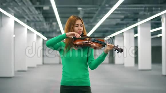 美丽的女士正在空厅里拉小提琴视频的预览图
