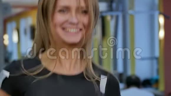微笑的女人在健身房跑步机上跑步视频的预览图