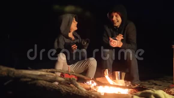 孩子们微笑孩子们喝茶青少年坐在篝火旁旅行徒步旅行生活方式冒险露营视频的预览图