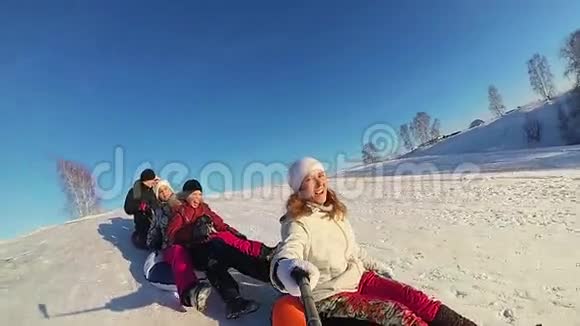 幸福的家庭乘坐和微笑的雪管在雪道上慢动作冬天的雪景户外运动日落视频的预览图