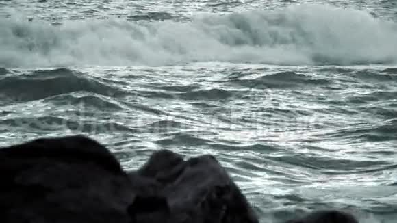 晚上的波浪和离焦岩石在前景慢动作视频的预览图