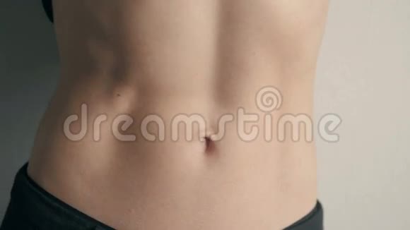 灰色背景下年轻运动员腹部肌肉的特写视频的预览图