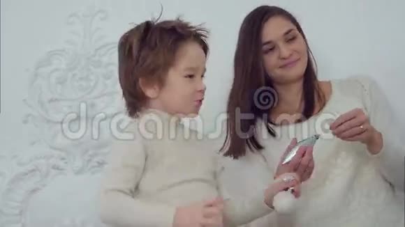 微笑的母亲和儿子在客厅装饰圣诞树视频的预览图