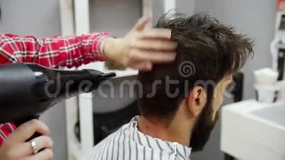 理发师将客户理发后的头发吹干慢动作视频的预览图