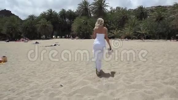 海滩上有棕榈树的女人视频的预览图
