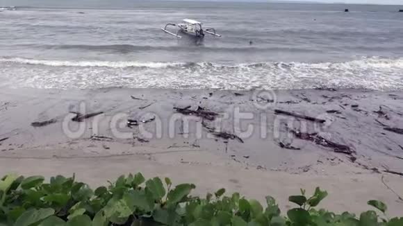 热带度假胜地淡季印度尼西亚巴厘岛大海波涛冲刷海滩上的垃圾和泥土视频的预览图