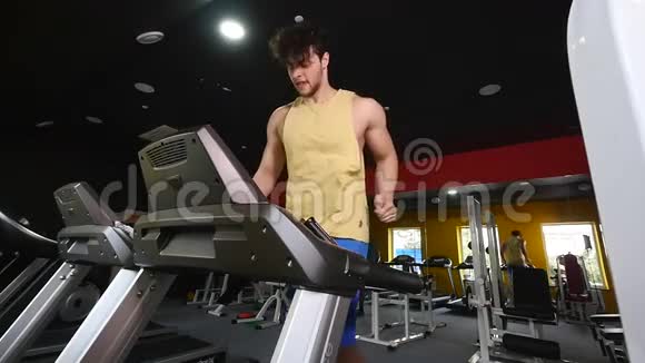 一个男人在健身房的跑步机上慢动作视频的预览图