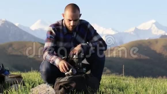 摄影师坐在室外专业摄像机上更换镜头视频的预览图
