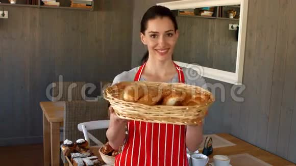 女面包师拿着篮子里的面包的画像视频的预览图