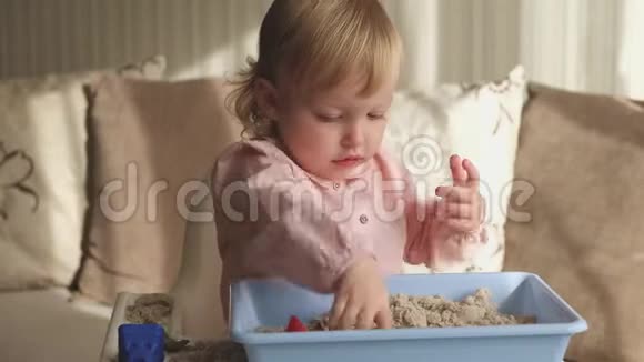 可爱的女婴在家玩动能沙沙堡游戏视频的预览图