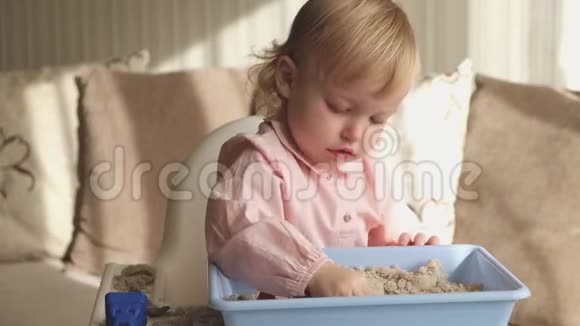 可爱的女婴在家玩动能沙沙堡游戏视频的预览图