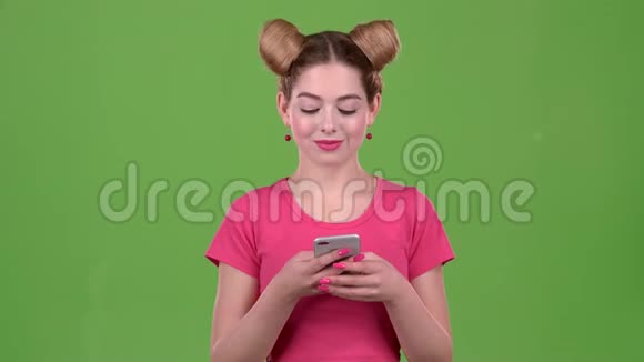 一个粉红色话题的青少年在电话上打印一条信息绿色屏幕视频的预览图