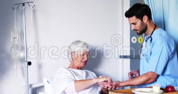 护士为女性老年病人提供药物视频的预览图