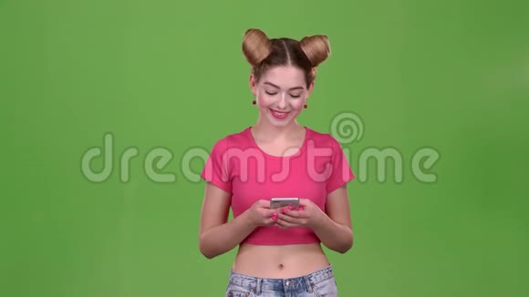 粉红色话题的女孩在电话上打印一条信息绿色屏幕视频的预览图