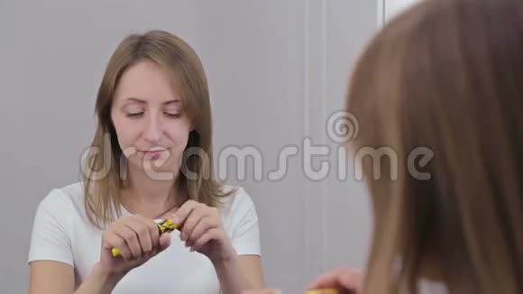 美丽的年轻女子把睫毛膏放在镜子前视频的预览图