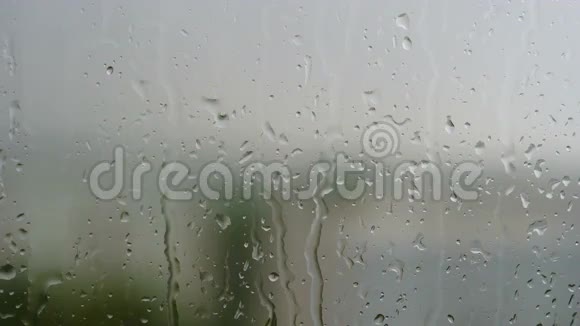 窗外夏日静雨水滴慢慢地顺着玻璃流下来雨敲窗台视频的预览图