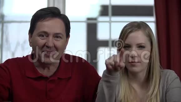 父亲和女儿直视着摄像机视频的预览图