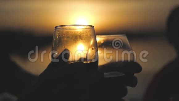 一群朋友带着酒杯和酒在夕阳的背景下伸手去拿酒却没有给它视频的预览图