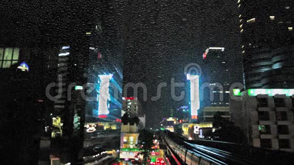 曼谷市中心的闪电和雨交通汽车和火车晚上透过窗户观看雨滴视频的预览图