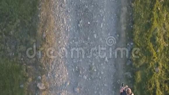 日落时在乡村路上奔跑的女人视频的预览图
