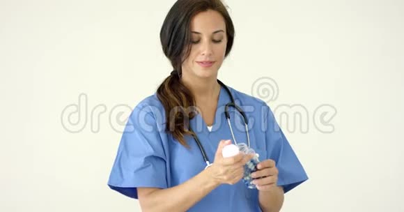 有魅力的女医生拿着药丸视频的预览图