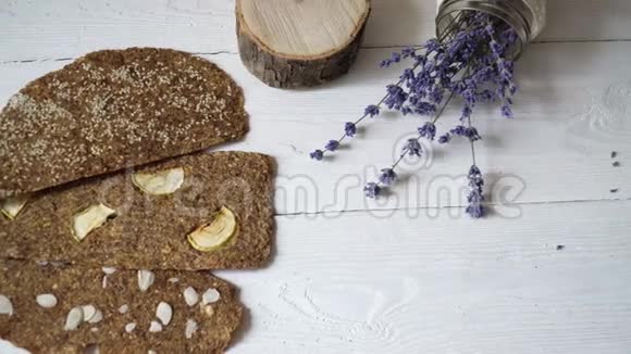 白色木制背景上有亚麻籽和杏仁的面包有益的膳食生面包纯素早餐不含酵母视频的预览图