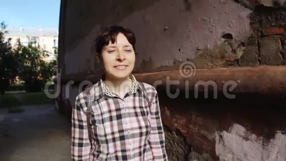 一个年轻的女人带着旧相机在老拱门上拍照视频的预览图