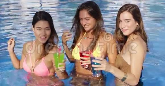 三位美女在泳池边喝着五颜六色的饮料视频的预览图