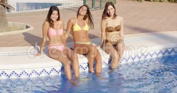 三个快乐的女人坐在泳池边视频的预览图