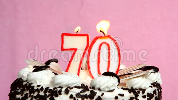 70周年纪念蛋糕和蜡烛放在粉色背景上视频的预览图