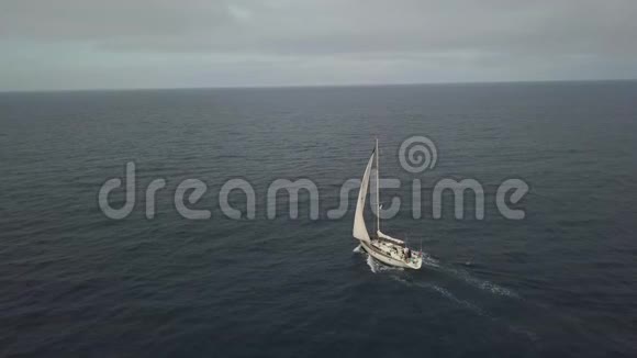 在多云的天际线空中风景中漂浮在蓝色海水中的运动帆船视频的预览图