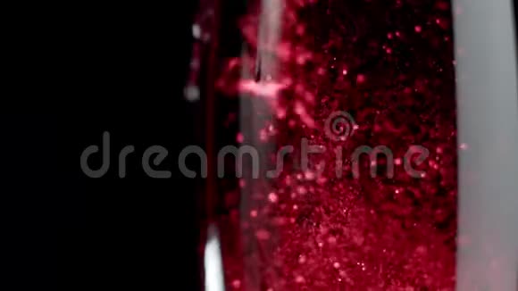 闪闪发光的红酒红酒被倒入一杯黑色的背景中视频的预览图