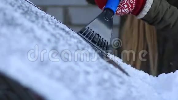 从汽车挡风玻璃上刮霜的女人视频的预览图